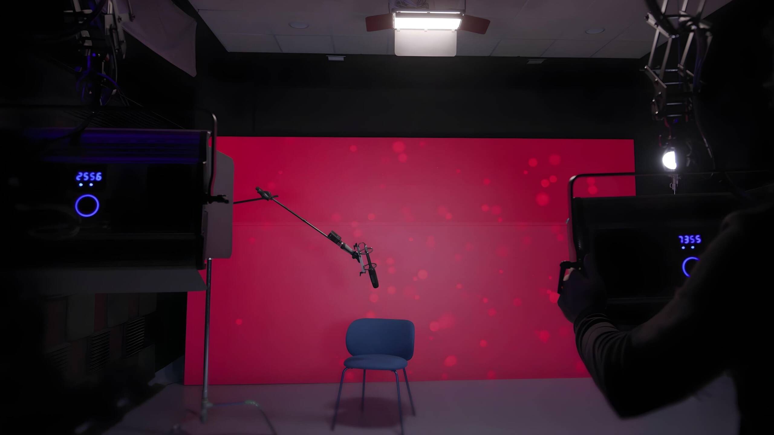 Plató con fondo rojo, microfonía suspendida e iluminación profesional.
